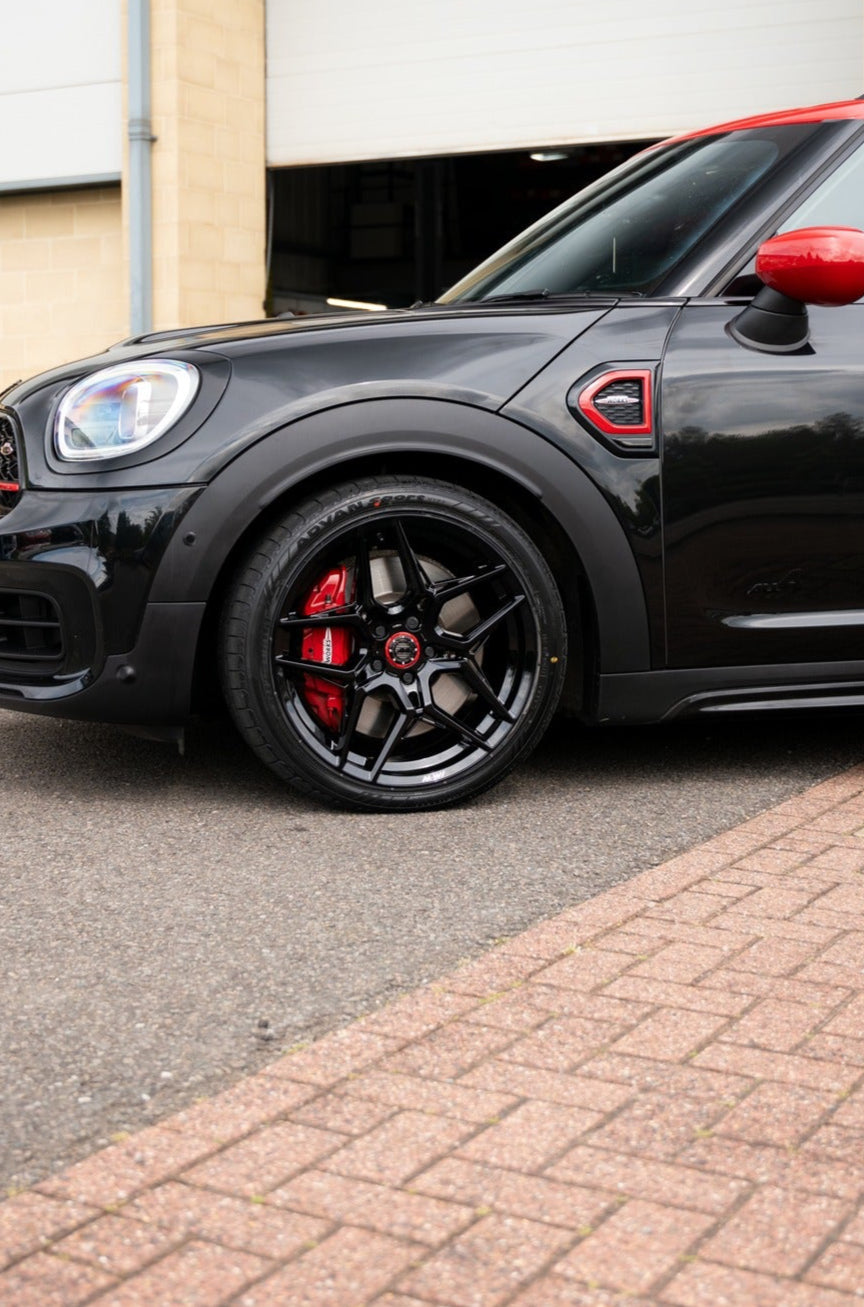 Mini with M-W1 Motech wheel and chilli red centre cap parked on a pavement.