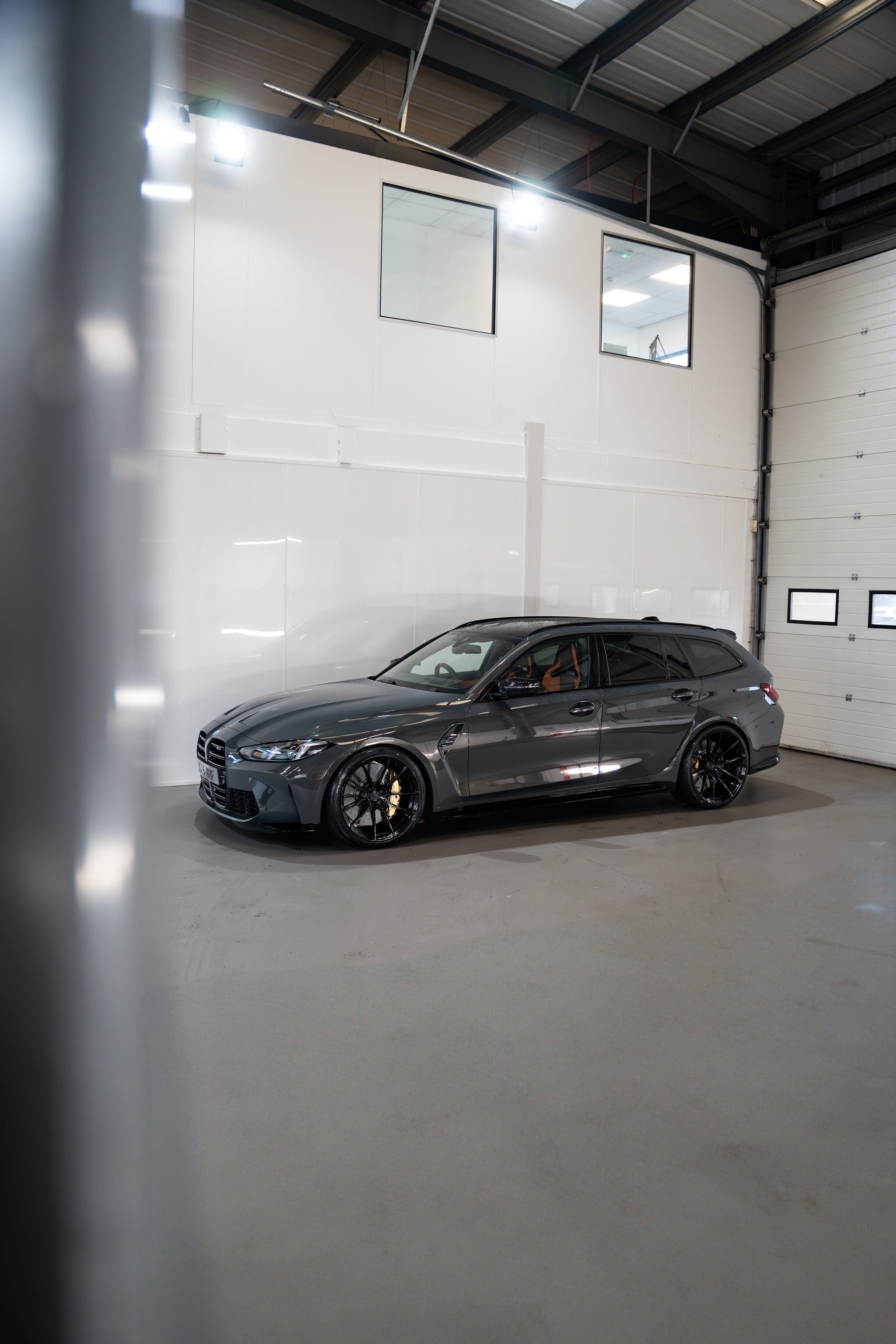 Grey G81 M3 Touring sat on Motech stance springs - parked in a car workshop.