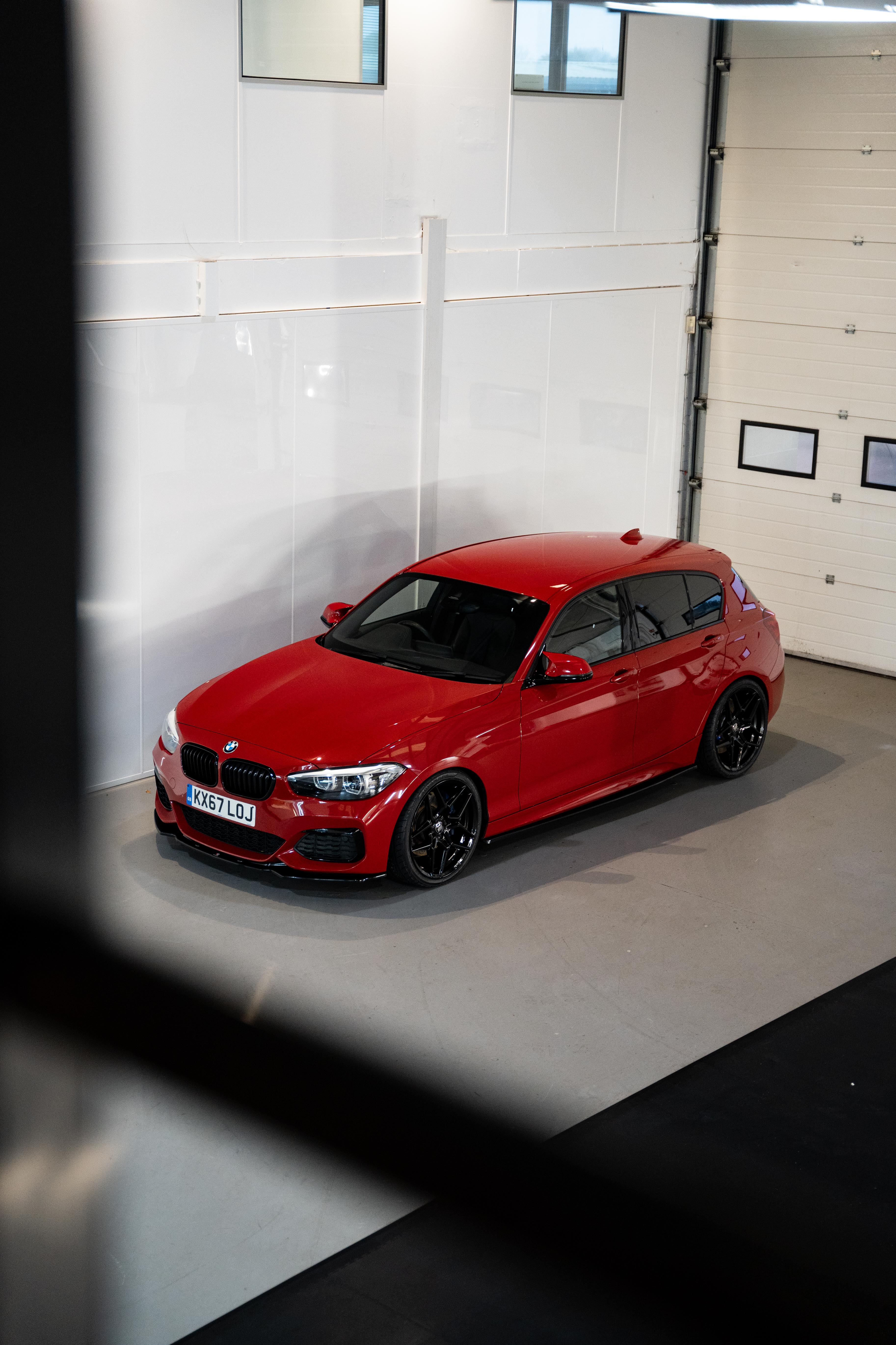 Front shot of a red BMW with Precision Black M-W1 Wheels in a workshop.