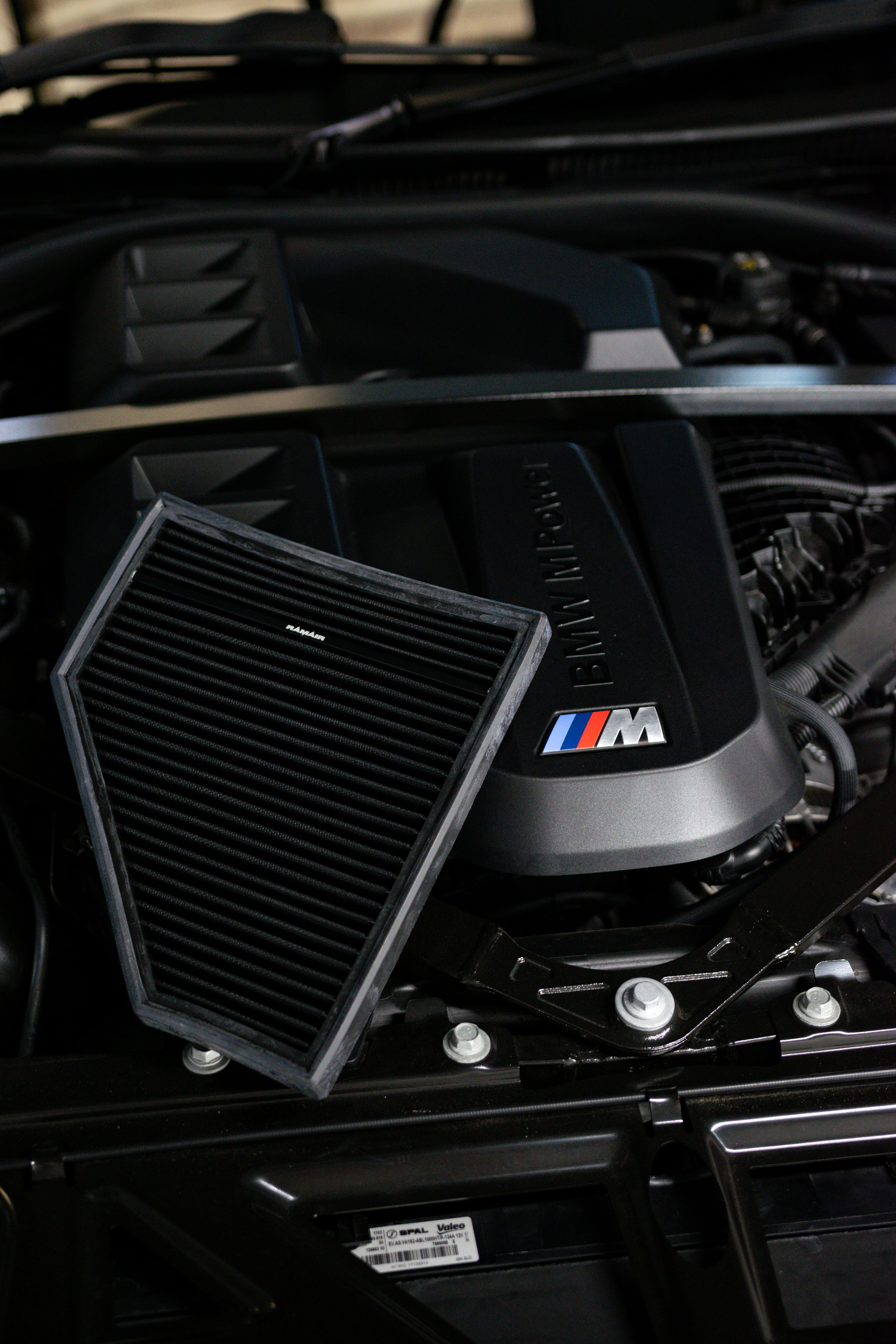 Close-up of a car engine with a prominent BMW logo and Ramair Air Filter.