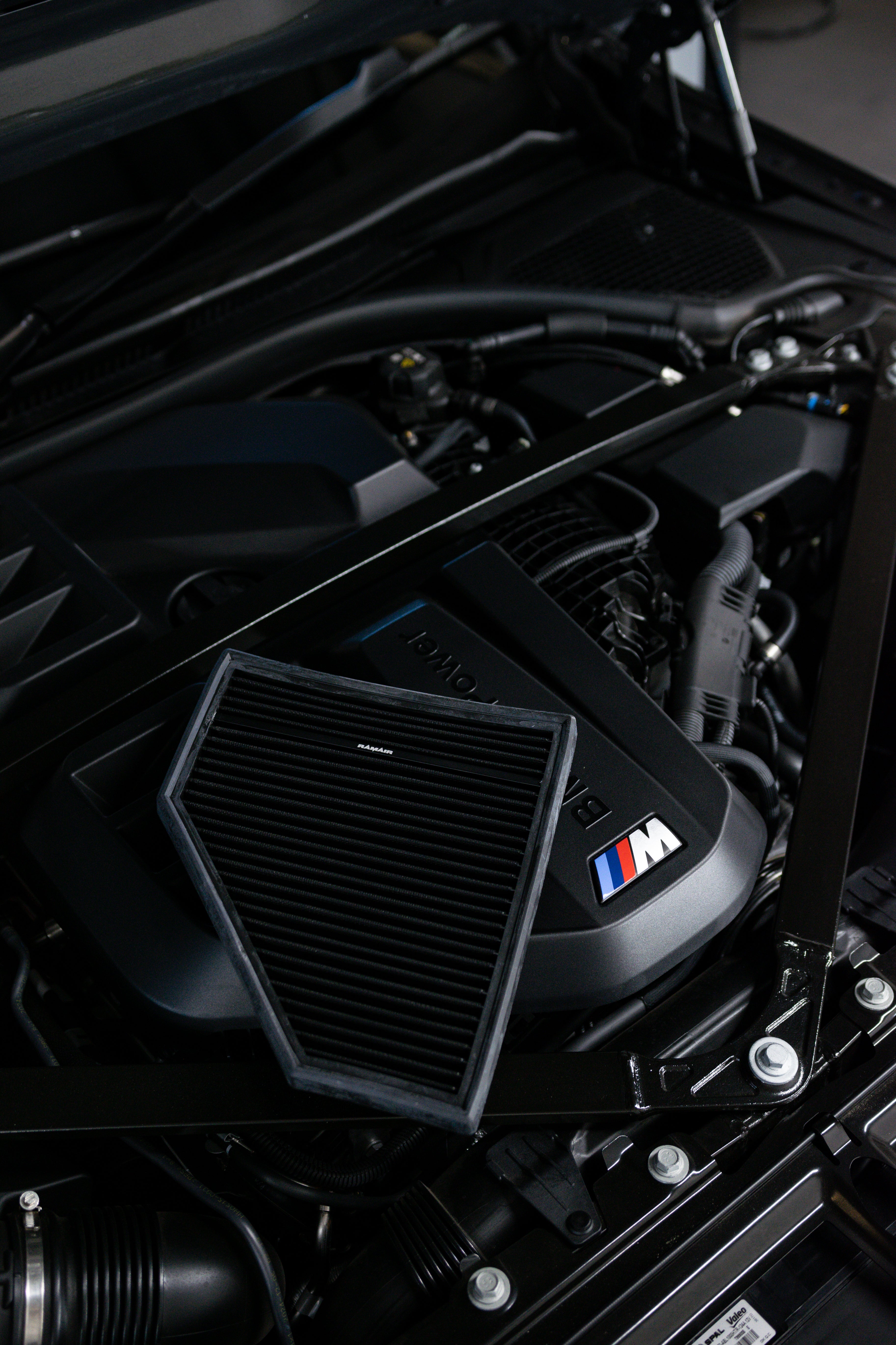 Close-up of a car engine with a prominent BMW logo and Ramair Air Filter.