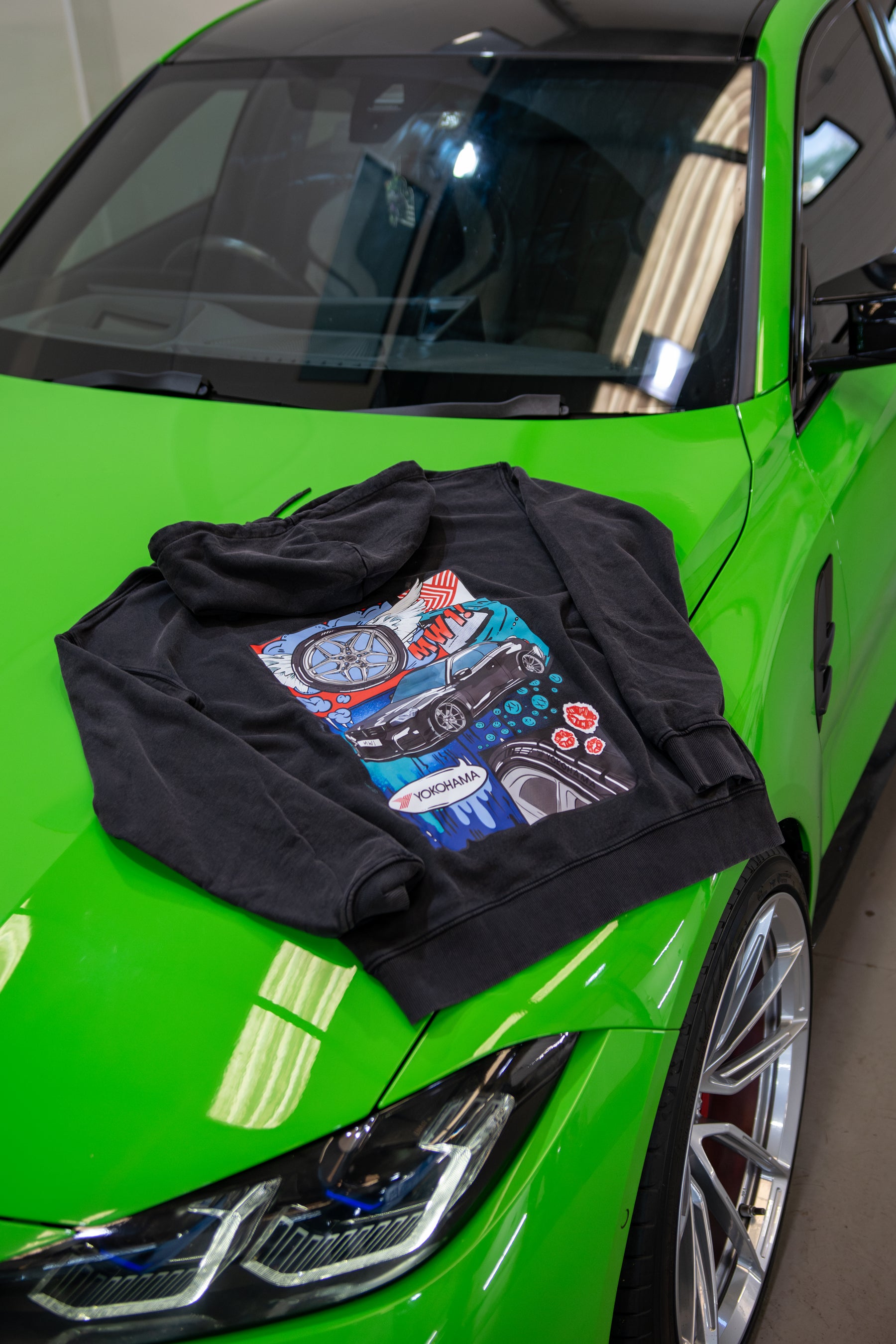Stone-washed Treadlight collection Motech hoodie with colorful graphic design on a green car