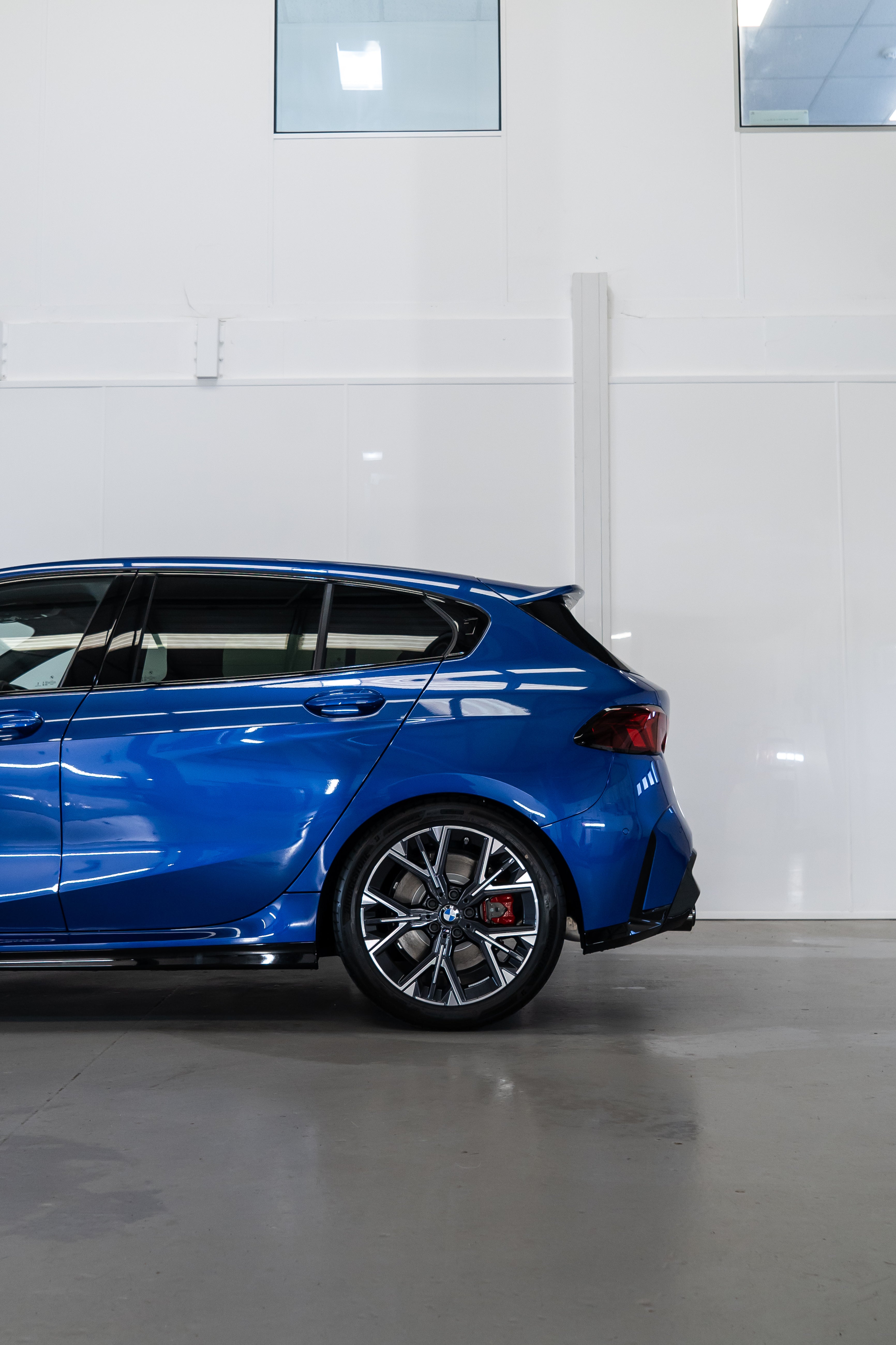 Back of a Blue BMW F70 with Motech stance springs parked in a workshop.