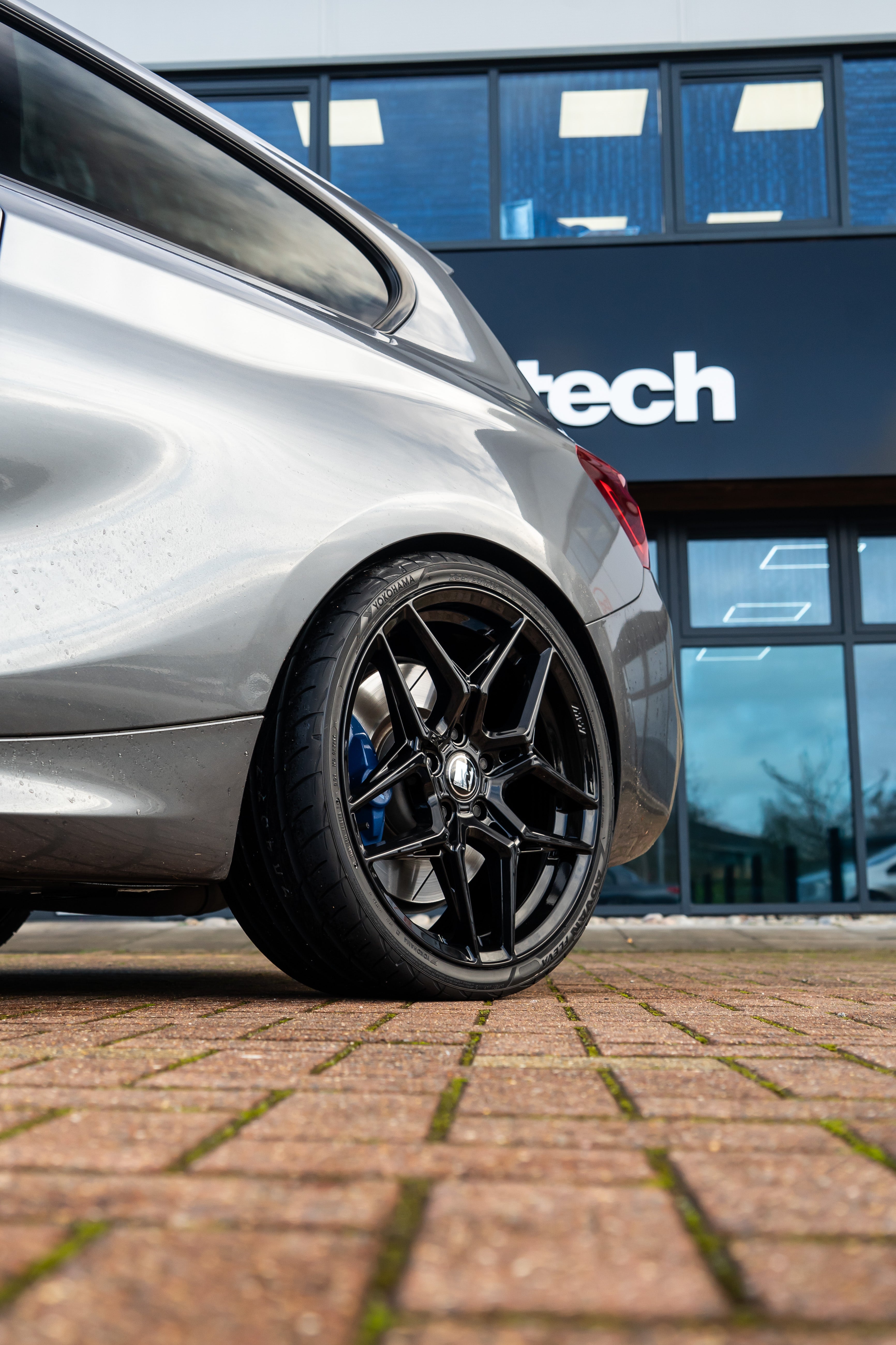 Rear-wheel shot of a grey BMW with Precision Black M-W1s.