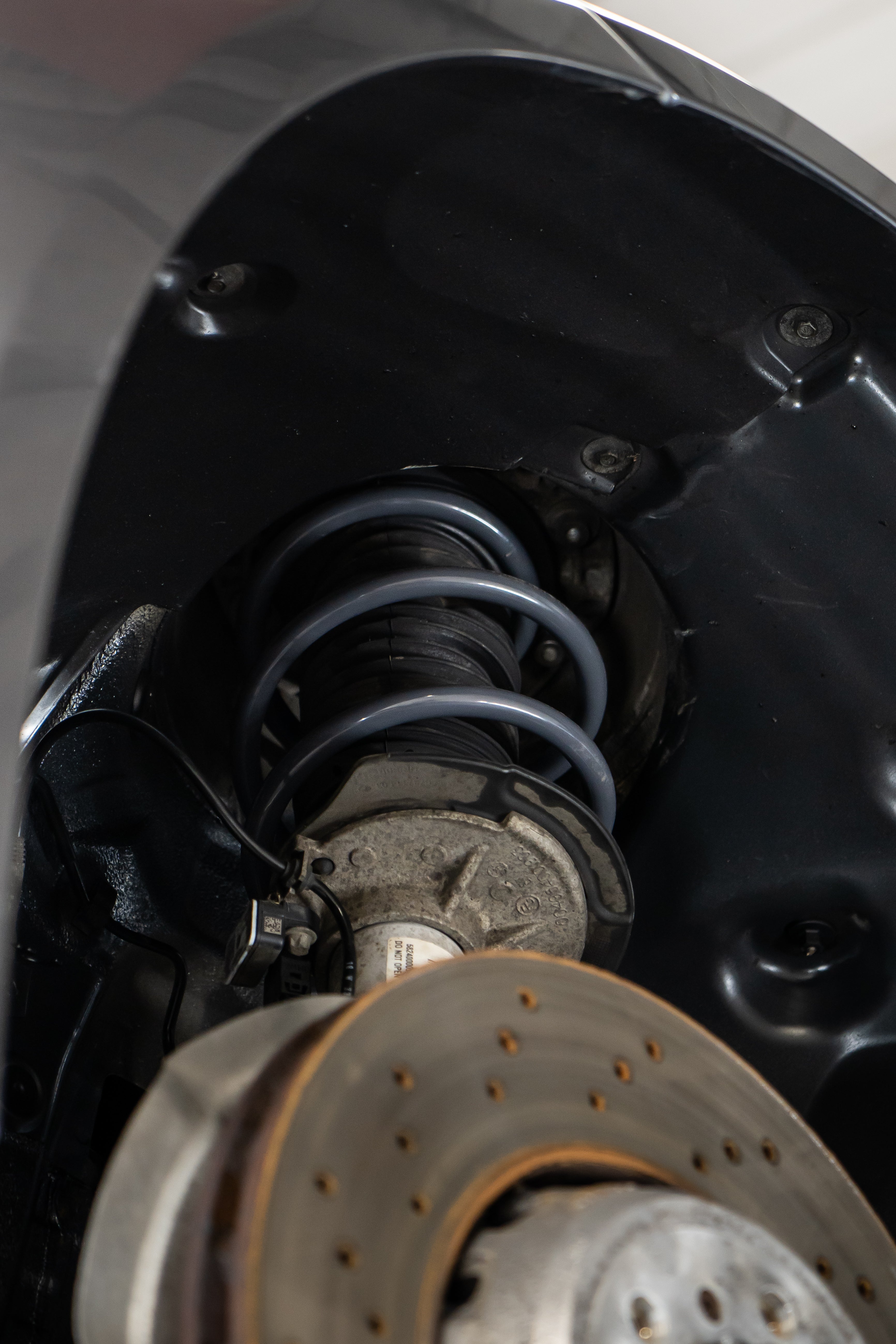 Close-up of a lowering spring fitted onto a car.