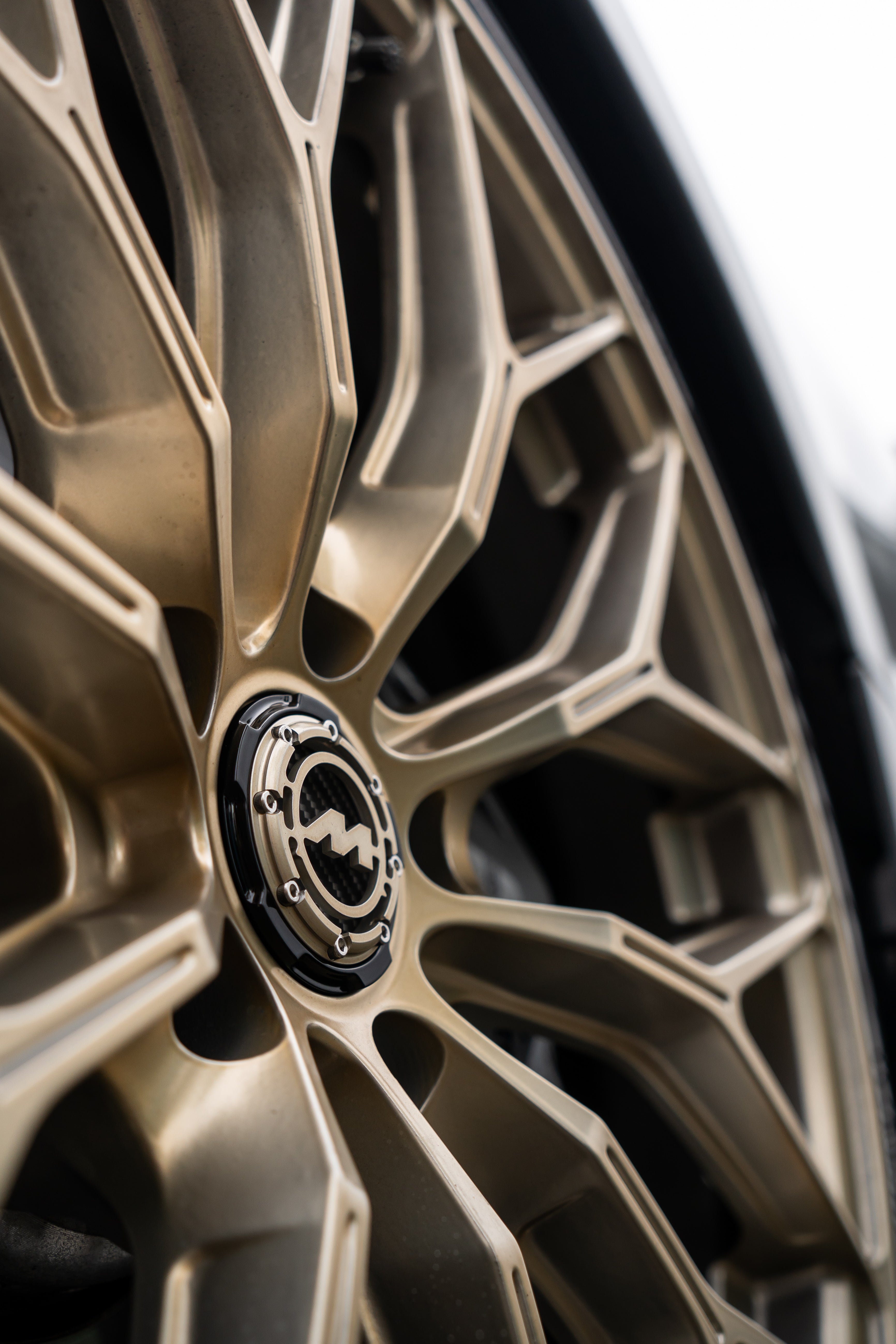 Close-up of a gold Motech wheel with a 3-piece centre cap.