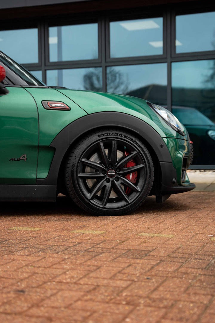 Front of a Green Mini Clubman on Motech Stance springs parked outside a building with 'Motech' branding.