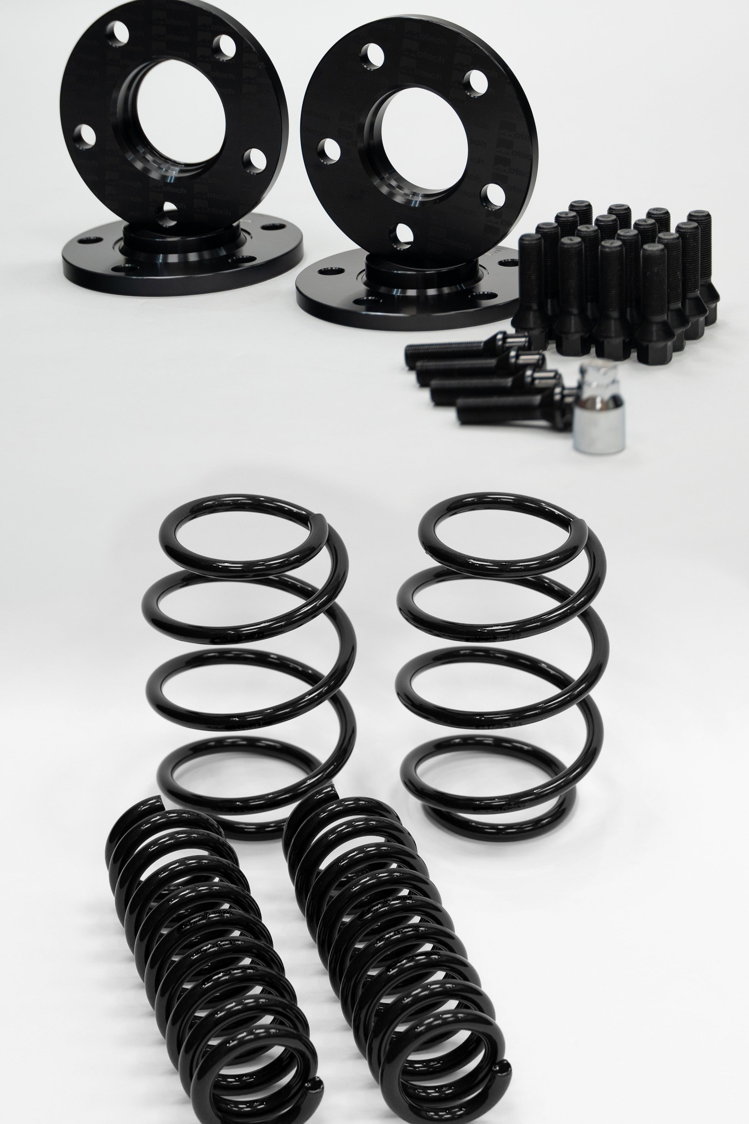 Set of black Motech wheel spacers, springs, and bolts on a white background