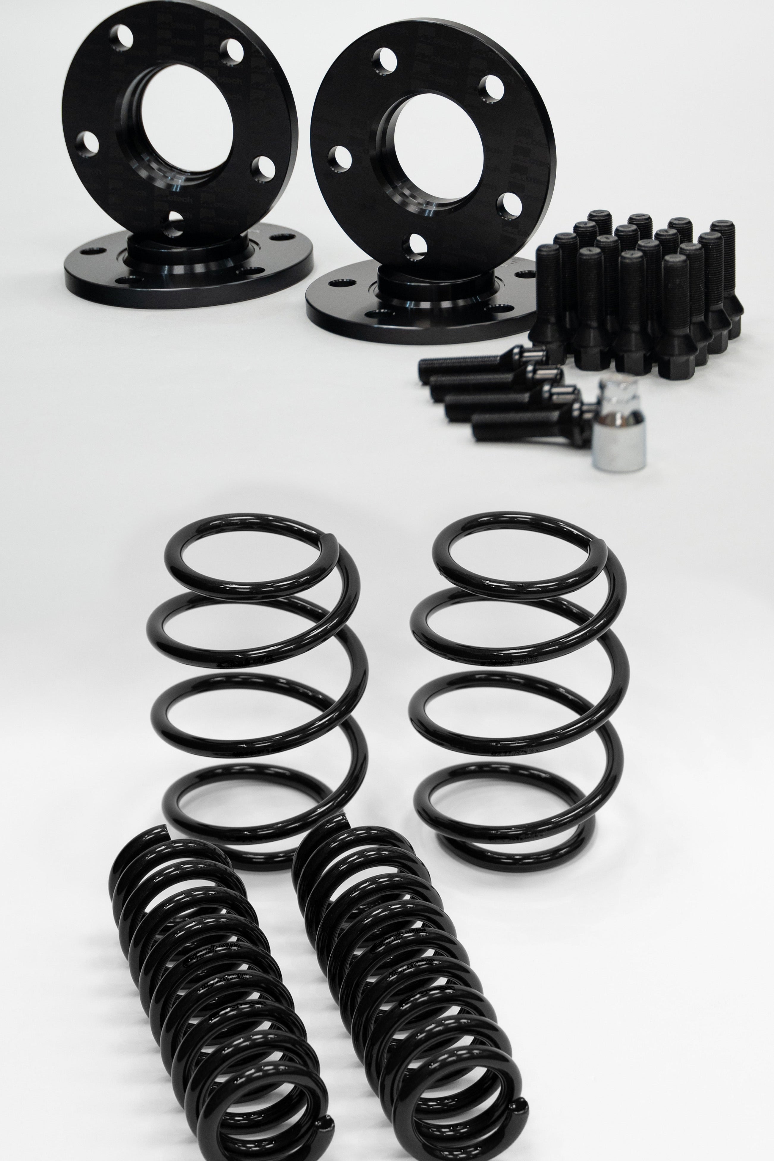 Set of black Motech wheel spacers, springs, and bolts on a white background