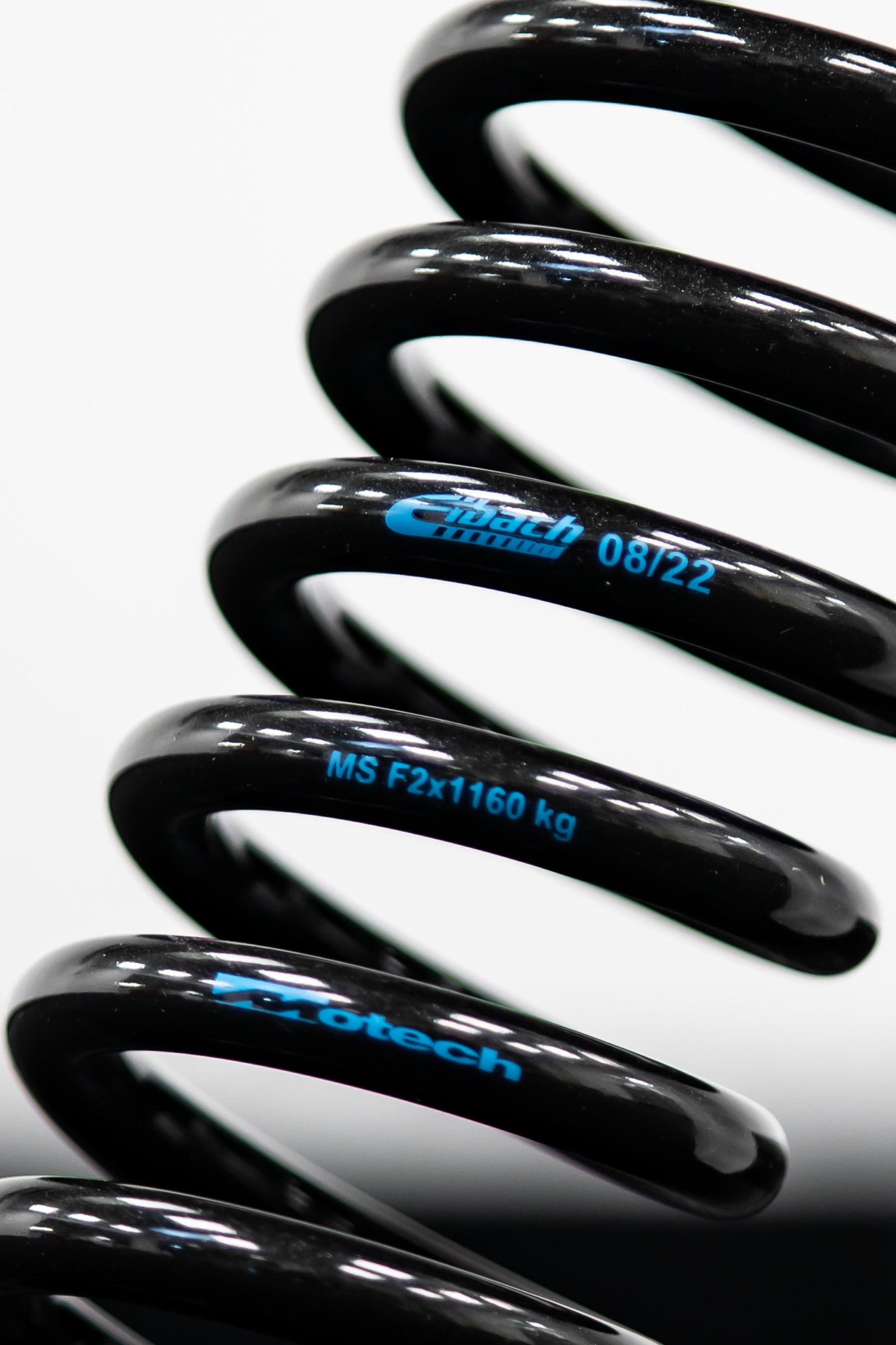 A close-up image of black metallic Eibach performance lowering springs with the Motech logo and part number inscribed.