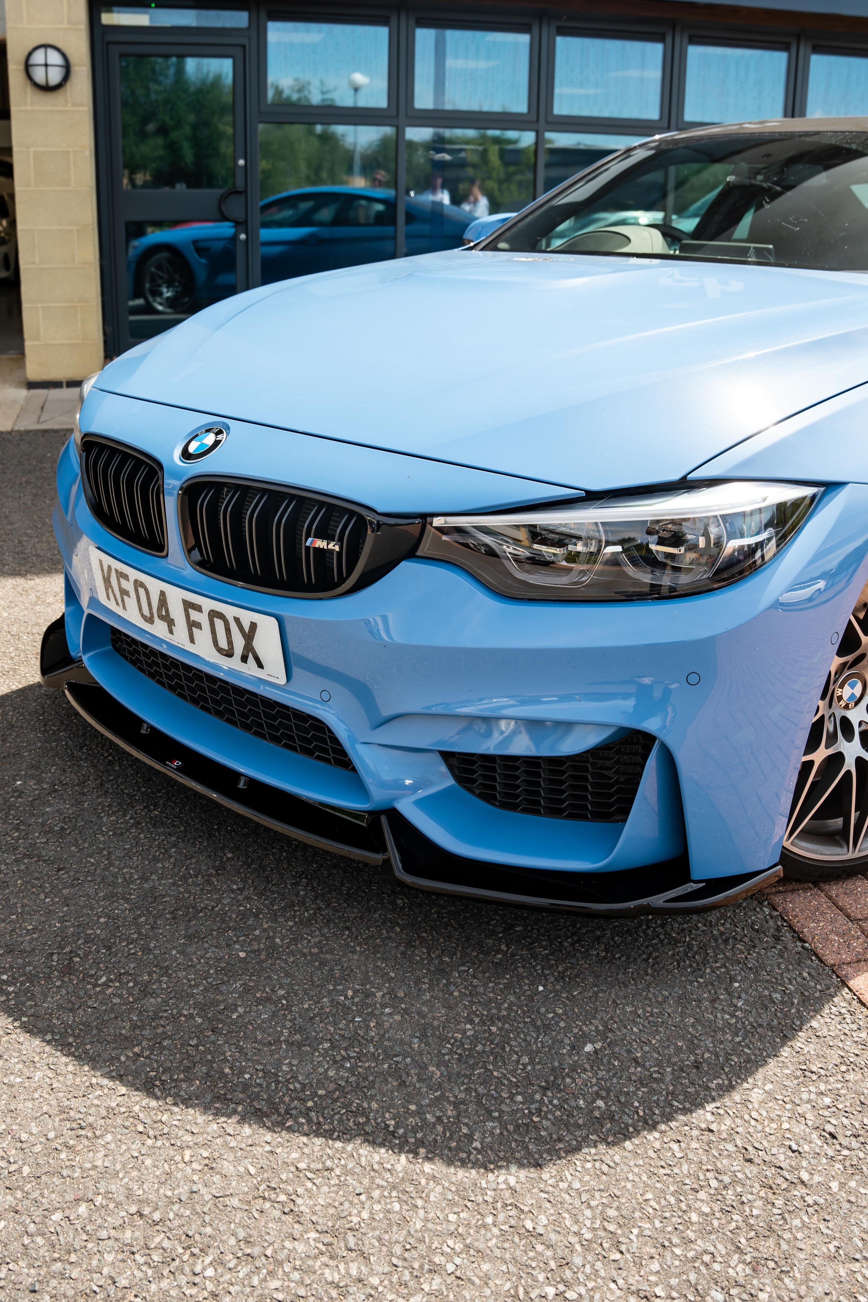 Front of a Blue BMW M4 F82 with aftermarket Maxton front splitter fitted. 