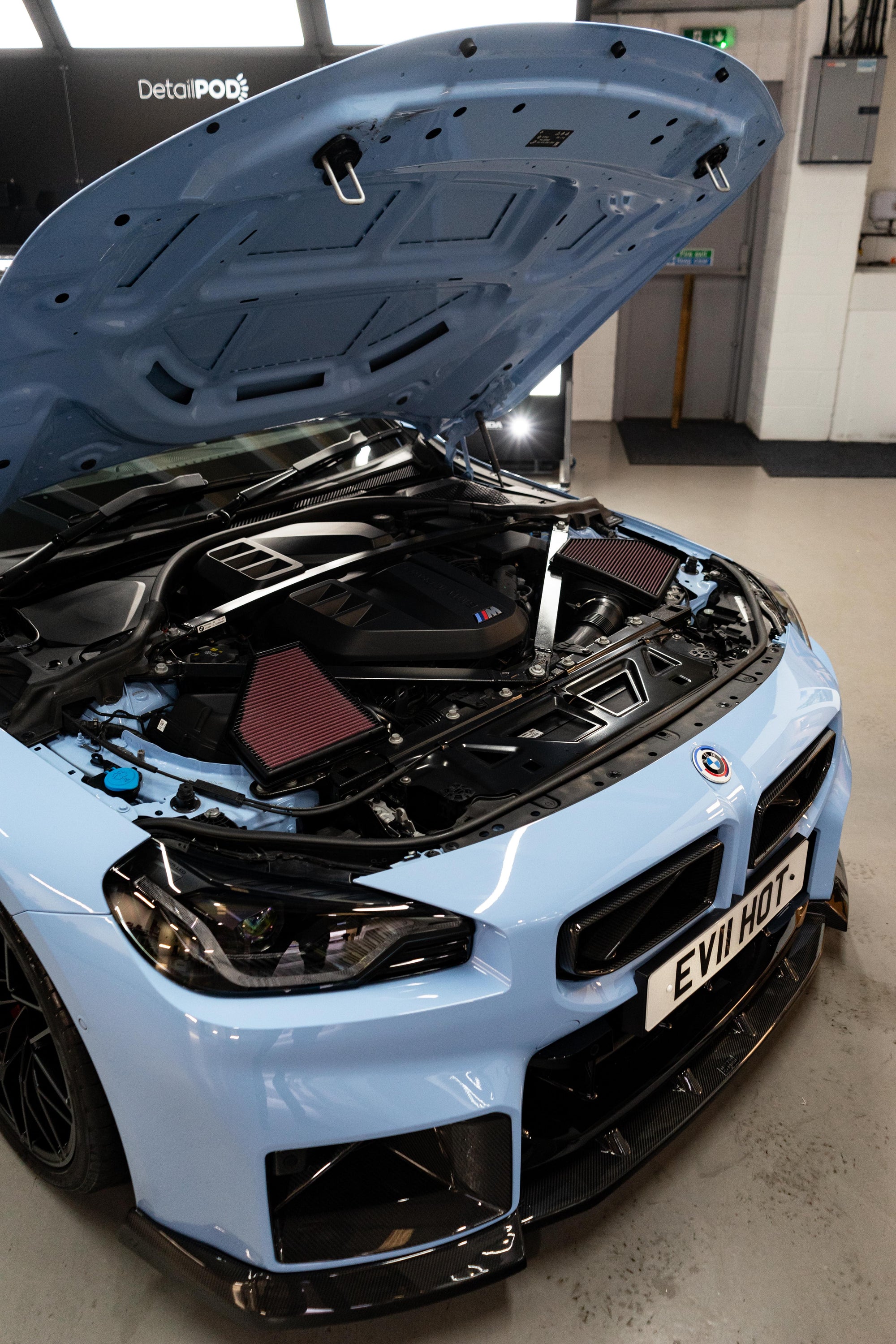 Light blue BMW M2 G87 with an open bonnet and K&N air filters on either side.
