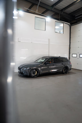 Grey G81 M3 Touring sat on Motech stance springs - parked in a car workshop.