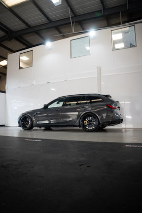 Grey G81 M3 Touring with M-W4's, Motech Stance Springs in a car workshop.