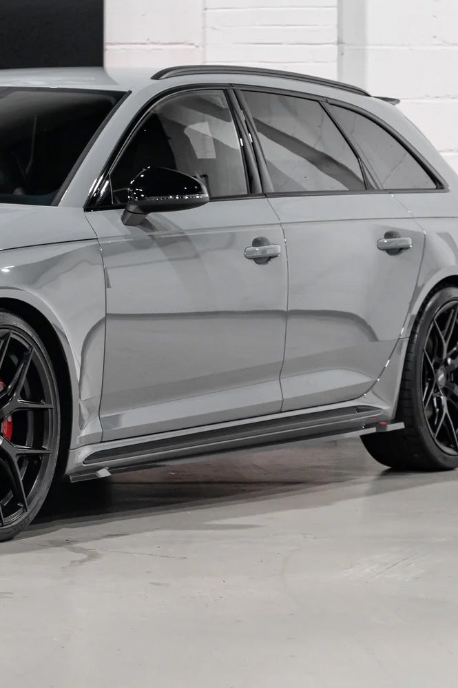 Silver car with black rims on a concrete floor and white wall background