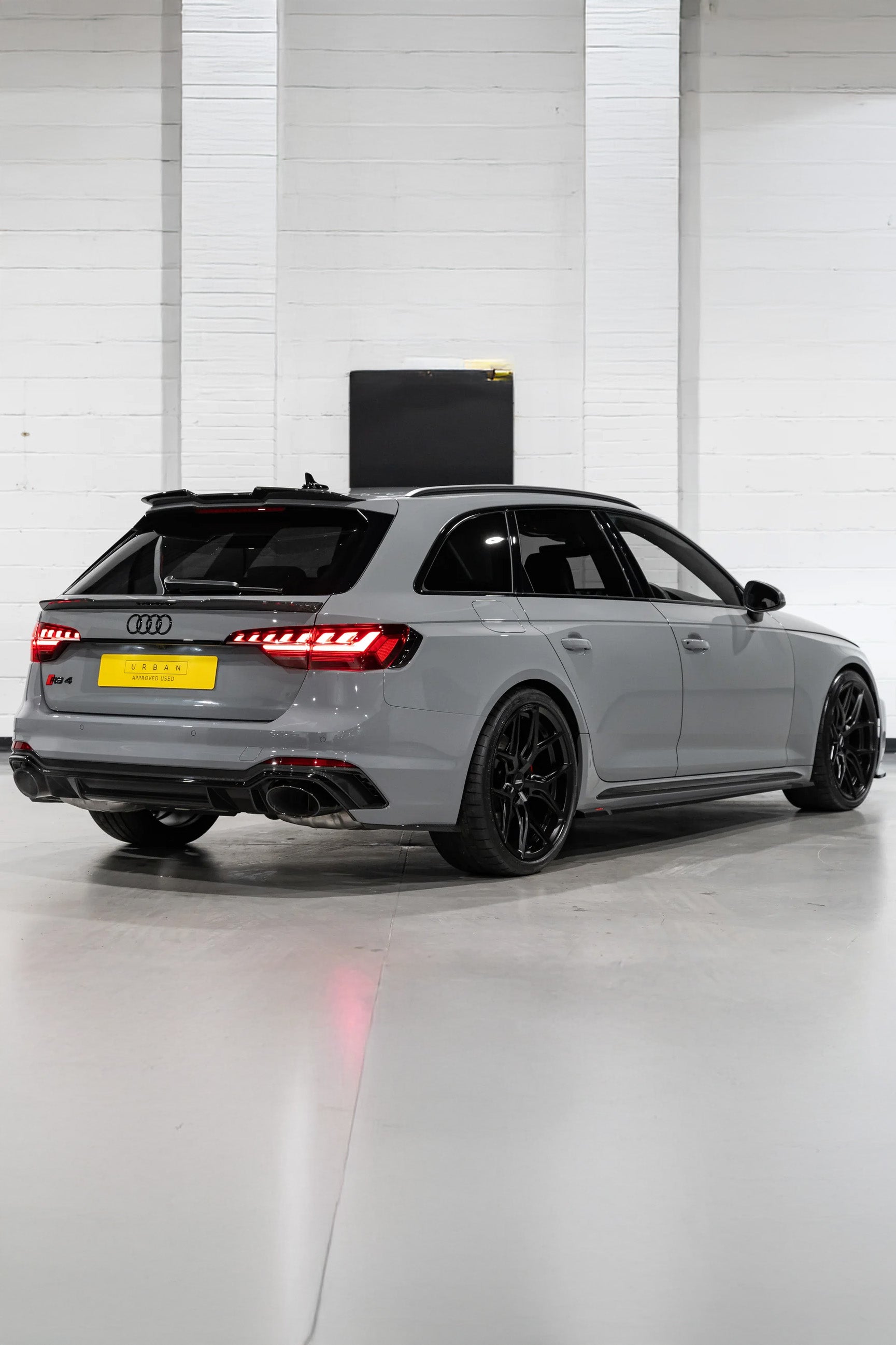 Audi RS4 with Carbon Styling & black rims in a white indoor setting