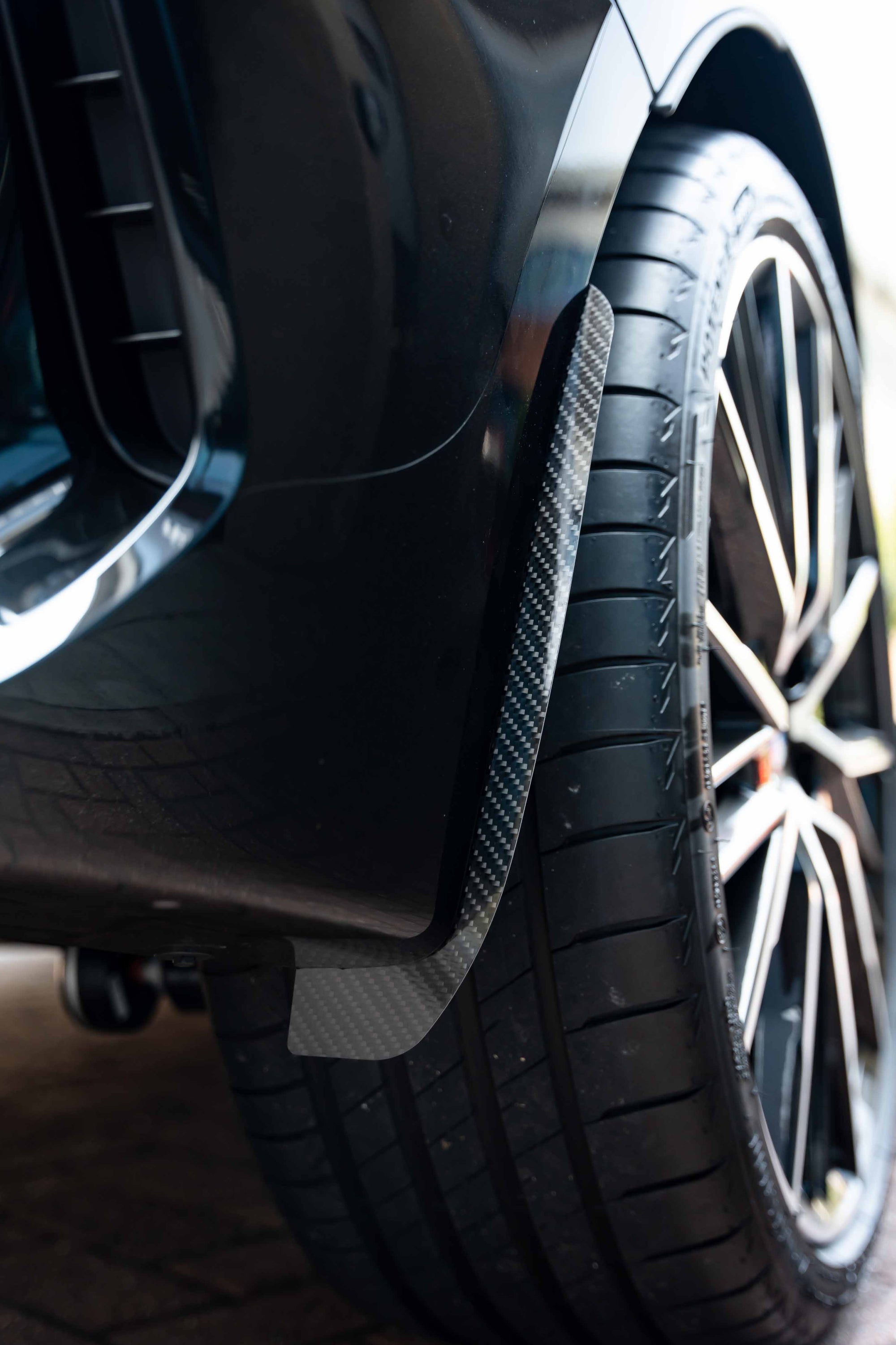 Back of a car wheel with a Carbon Arch guard fitted onto the car.