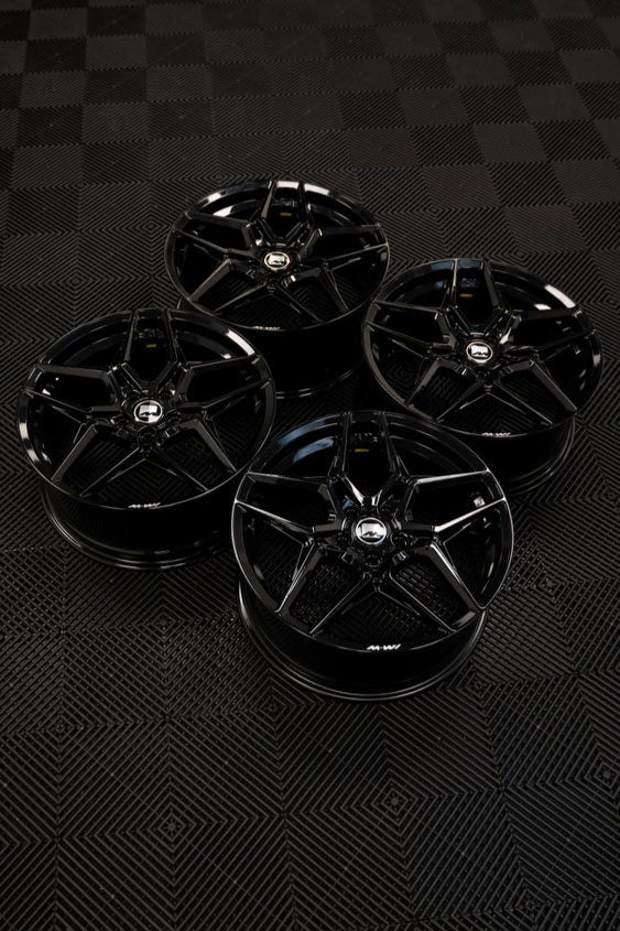 4 Precision Black M-W1 Wheels in a workshop.