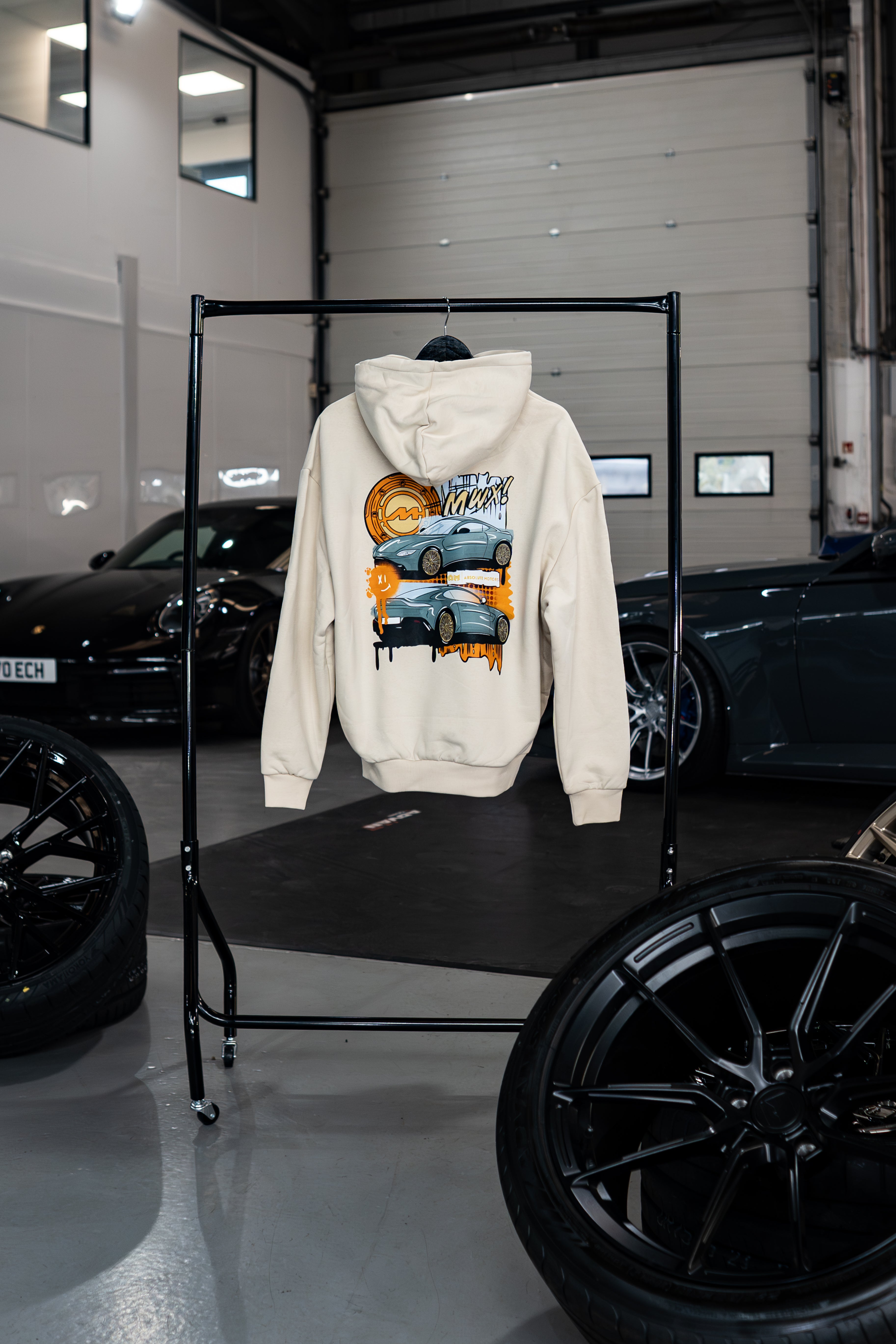 Vantage Collection Sandstorm hoodie with car graphic on a rack in a garage setting