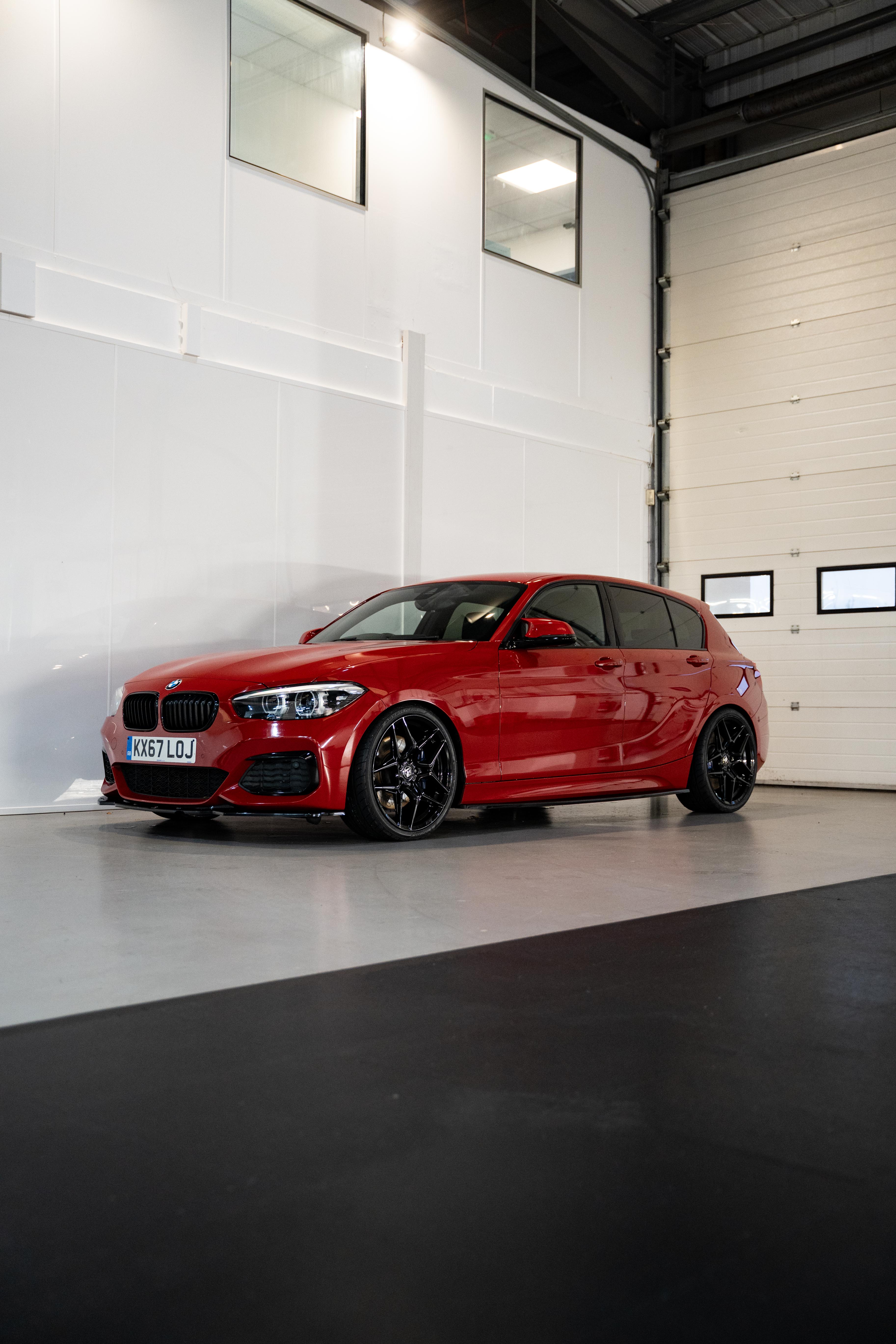 Full shot of a red BMW with Precision Black M-W1's in a workshop.
