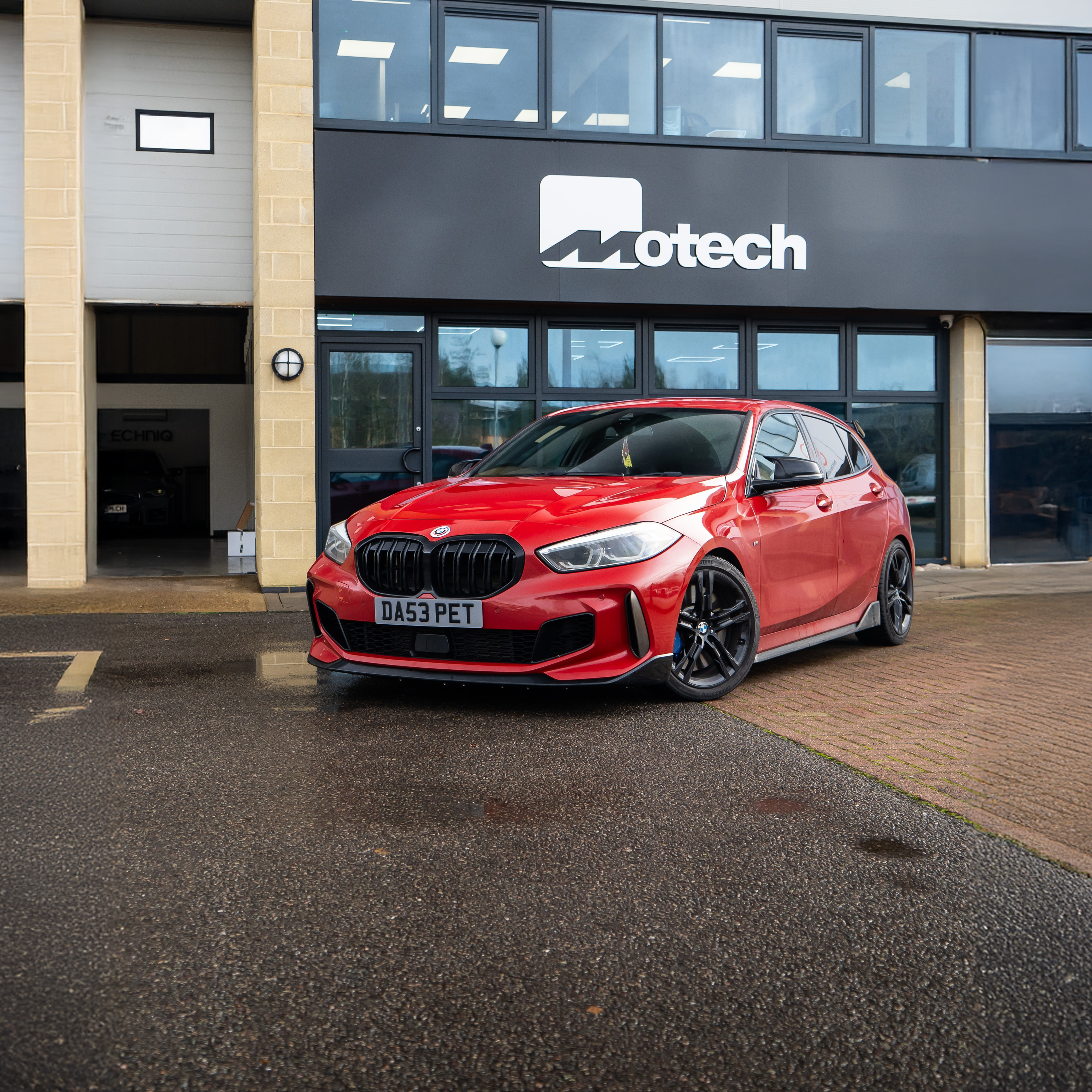 Red BMW lowered with Springs & Spacers.