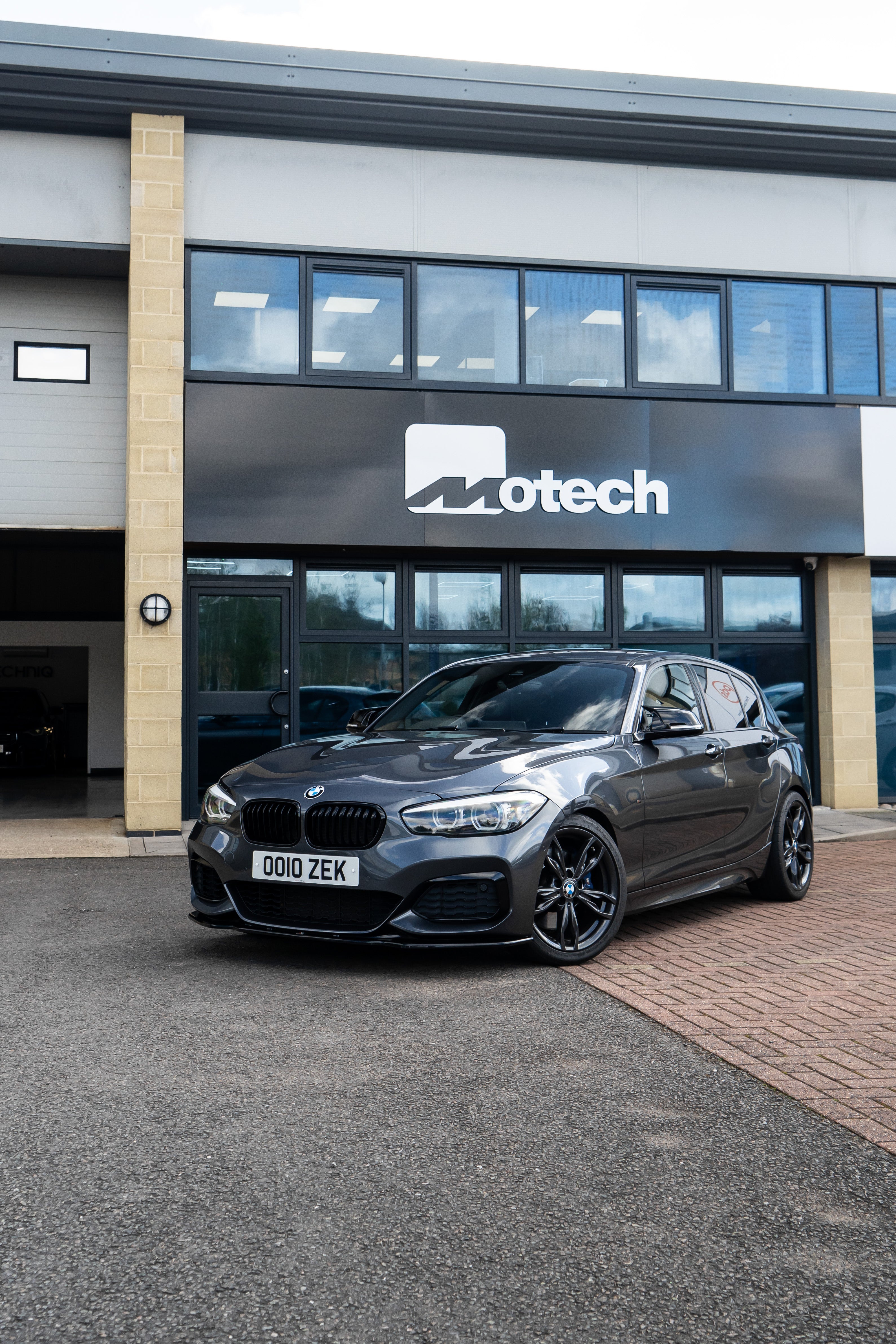 Grey BMW car on Motech Stance Springs outside the Motech building. 