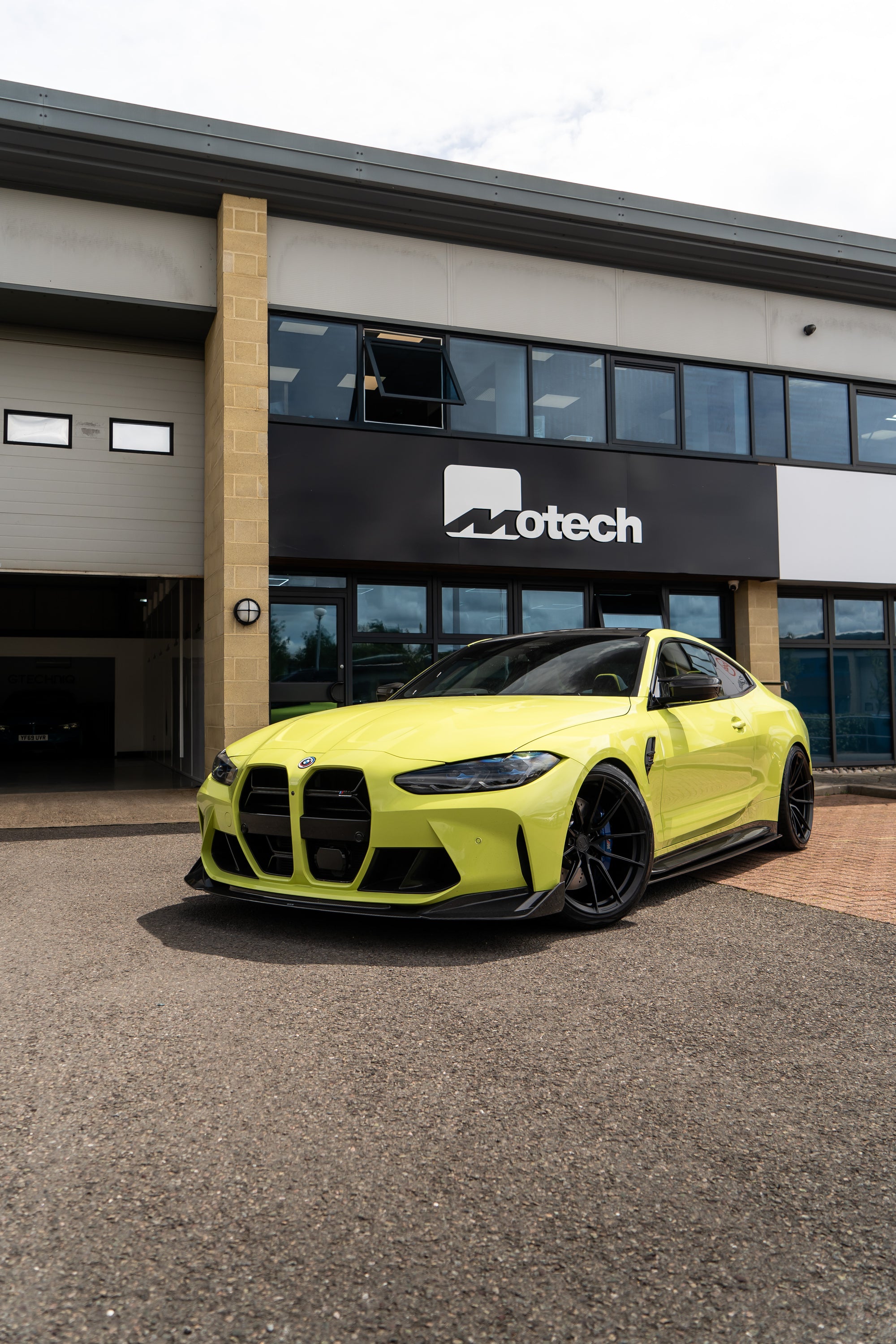 São Paulo Yellow BMW lowered with Springs & Spacers outside a building with 'Motech' branding.