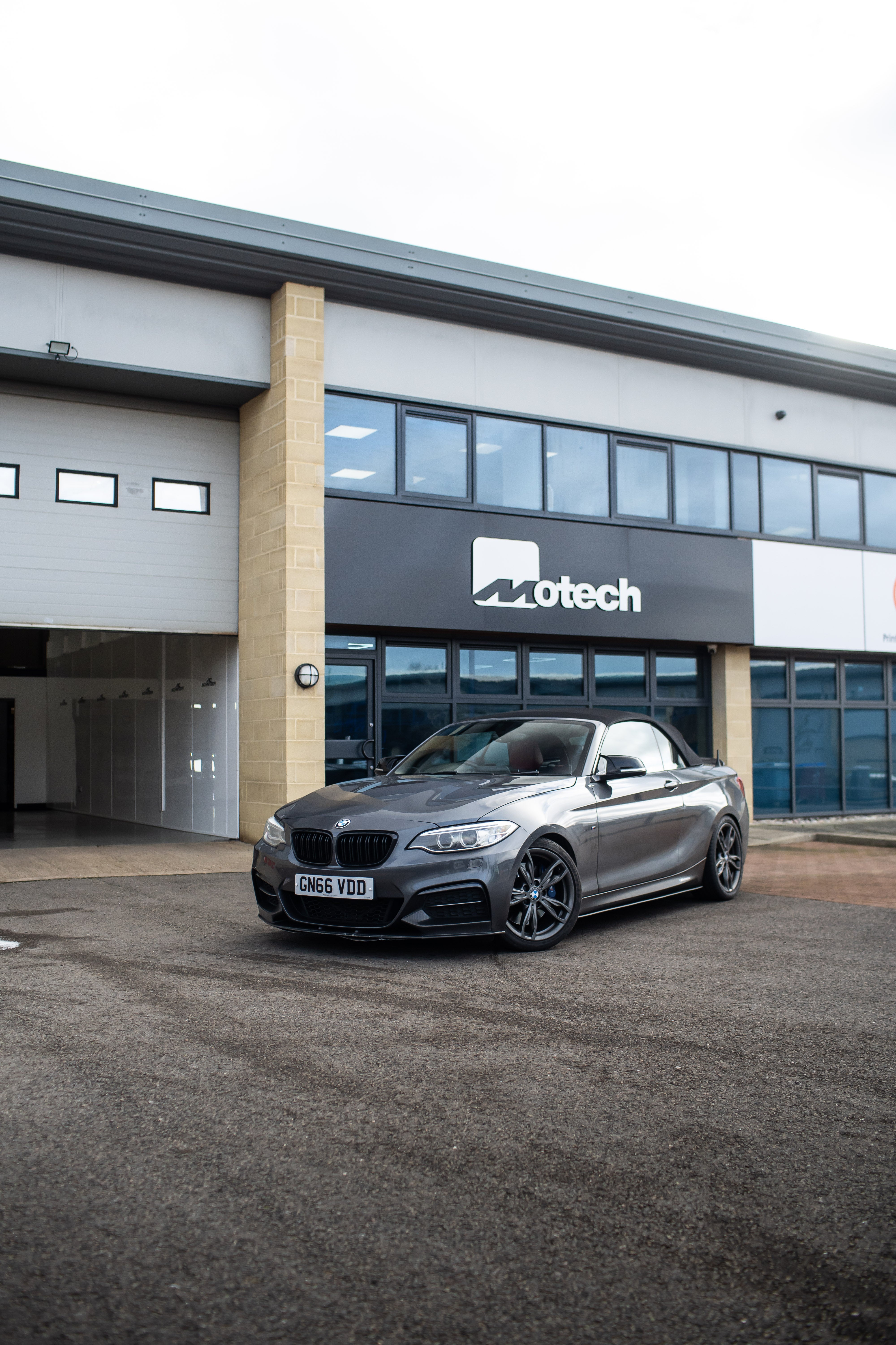 Grey BMW 2 Series on Motech Stance Springs parked outside the Motech building.
