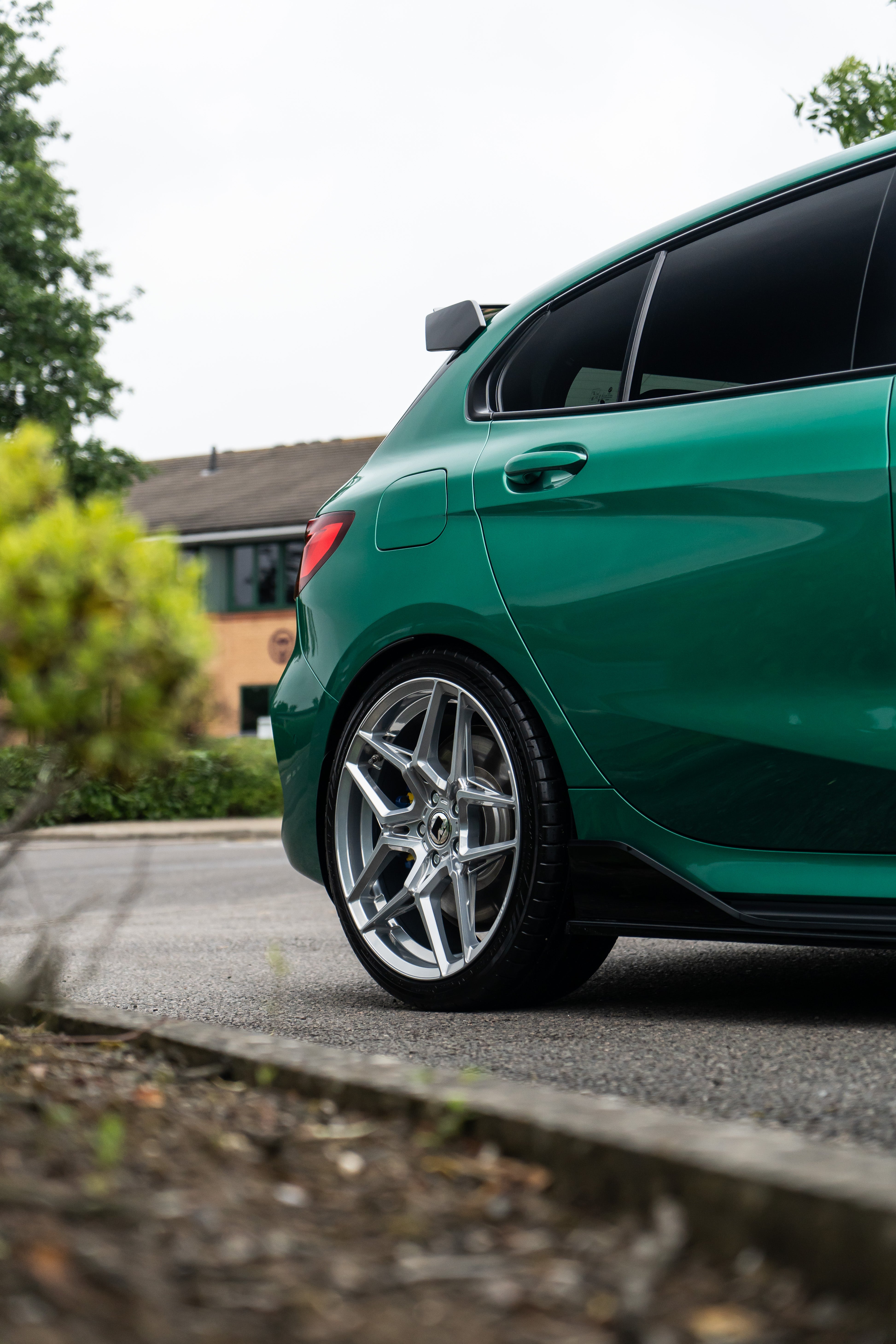 Back wheel of a green 1 Series BMW