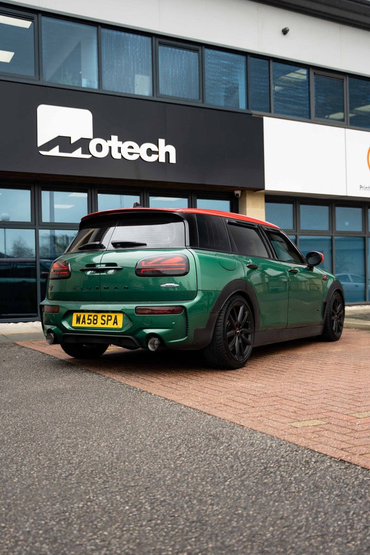 Green Mini Clubman on Motech Stance springs parked outside a building with 'Motech' branding.