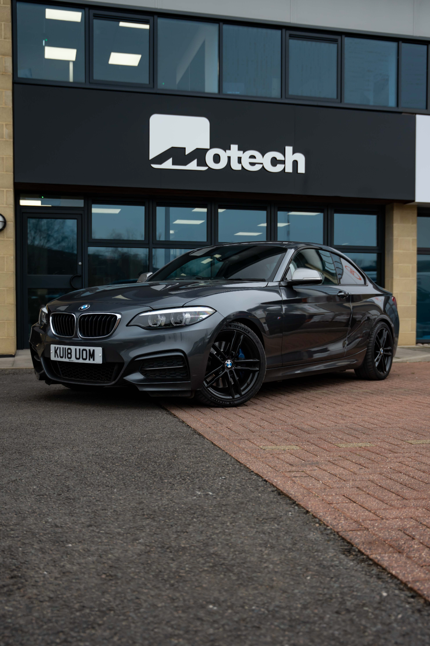 Grey BMW 2 Series on Motech Stance Springs parked outside the Motech building.